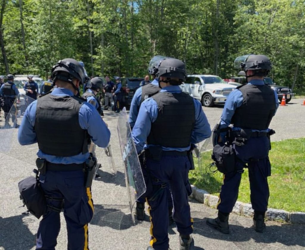 Royal security personnel in tactical gear at outdoor event, ensuring safety and protection.